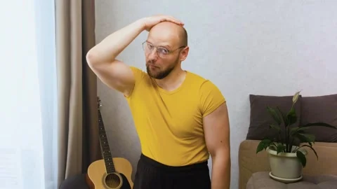 Bald inept seducer nerd moves his eyebrows, preens, flirts and points his finger Stock Footage 243756750