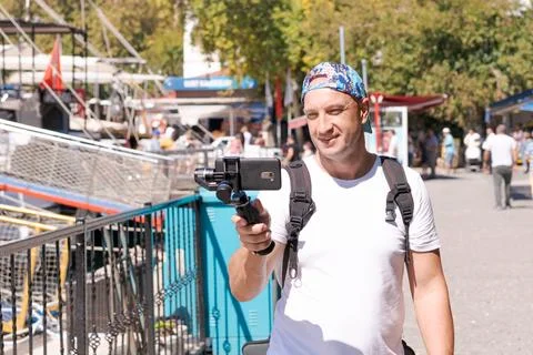 Bald Man with Action Camera Stabilizer Walks at Street Smiling Stock Photos