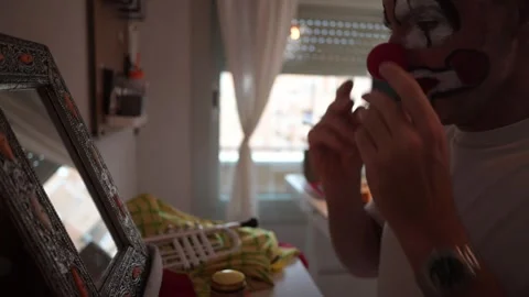Bald man applying clown make-up and smiling at the camera Video stock 323804460