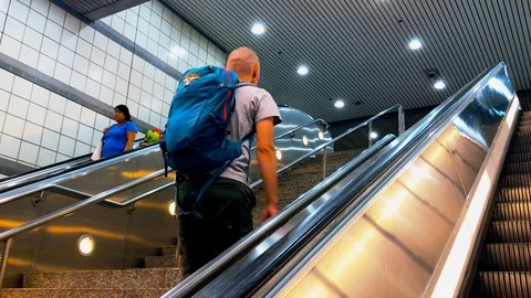 Bald man with a backpack on his back climbs the escalator. Stock Footage 126370437