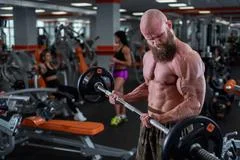 Foto de Brutal, muscular, bald with a beard athlete in the gym