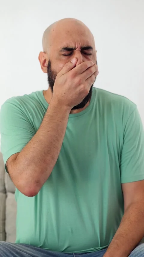 Bald man with beard yawning on the couch out of boredom Stock Footage 295141871