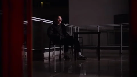 Bald man in black clothes sitting on the balcony Video stock 258540770