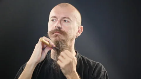 Bald man brushing long beard Stock Footage 41697697