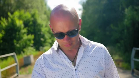 A bald man going along on an abandoned railway bridge and sings. Close up shot. Stock Footage 114982020