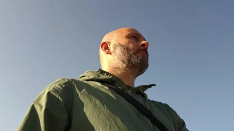 Bald man with green jacket looking up to the sky Vidéo 315360437