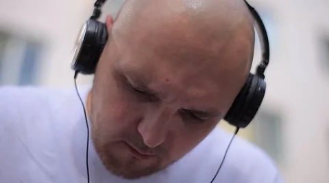 Bald Man With Headphones Looking Down Stock Footage 67708678
