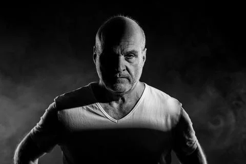Bald man with intense expression and dramatic lighting Stock Photos