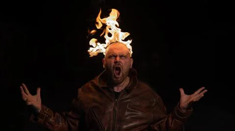 Bald man in a leather jacket with a burning head on a dark background. Stock Photos