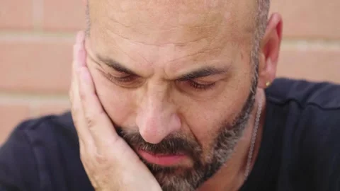 Bald man looking sad with brick wall background Stock Footage 278365262