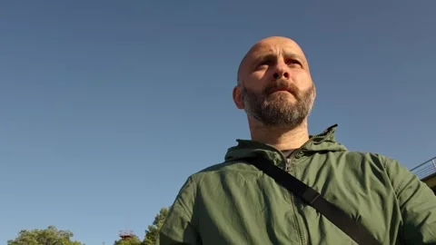 Bald man looking up at the sky near a bridge Stock Footage 315360902