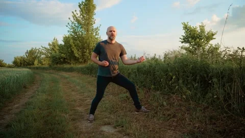 Bald man passionately performing on imaginary guitar, striking dynamic pose like Stock Footage 303497075