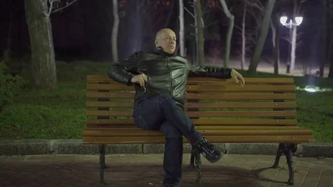 The Bald Man Pulled Out His Cellphone and Typing a Message While Sitting on a Stock Footage 74949169