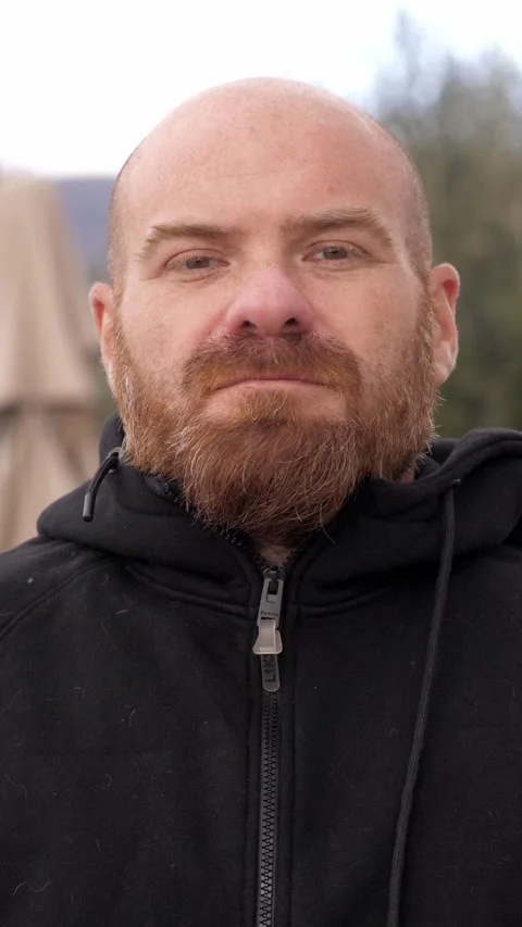 Bald Man with Red Beard Looking Serious Towards the Camera in the Park Stock Footage 295184551