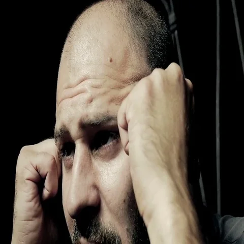 Bald man reflects on his future with his head in his hands Stock-Footage 69513582