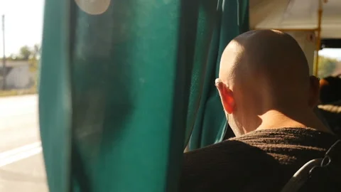 Bald man riding on a bus. Sunlight in the window. Close-up Video stock 128287829