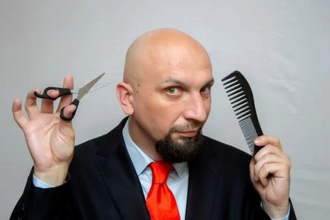 Bald man with scissors and a comb in his hands, haircut in the Barber shop Foto stock