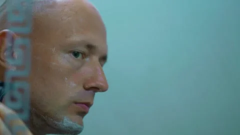 Bald man shaving in front of bathroom mirror Stock Footage 249277973