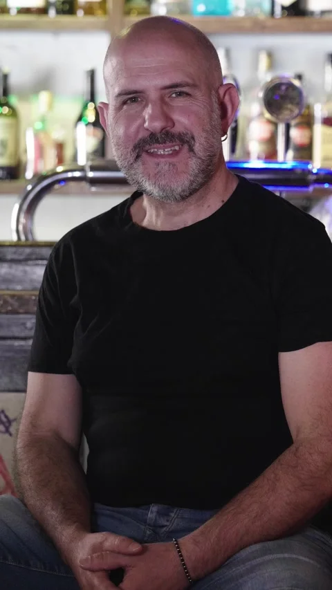 Bald man sits in pub smiling towards the camera, mature man Stock Footage 285540760