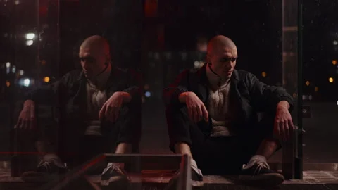 Bald man sitting in the dark Vídeo Stock 258528696