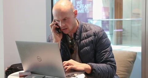 Bald man on smartphone while using computer Stock Footage 89461844