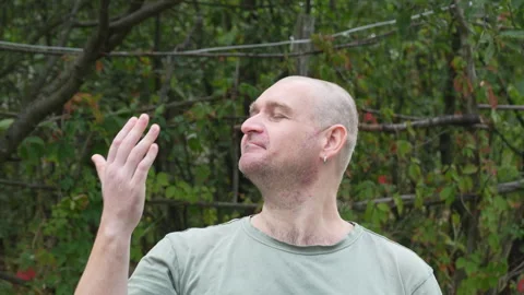 Bald man strokes his head and shows approval gesture outdoors Stock Footage 317841771