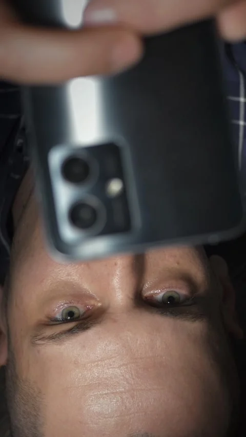 Bald man uses a smartphone while lying on the floor. Stock Footage 321353424