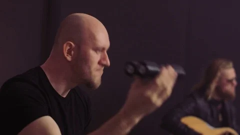 Bald Man Using a Rattle and a Guitarist Stock Footage 75116625