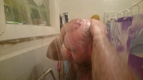 Bald man washes under a shower Stock Footage 49871130