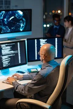 Bald mature businessman decoding data on computer screen Stock Photos