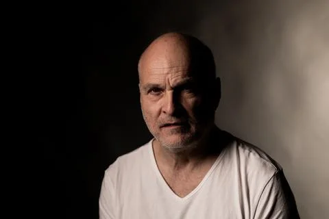 Bald middle aged man feeling frustrated with dramatic lighting Stock Photos