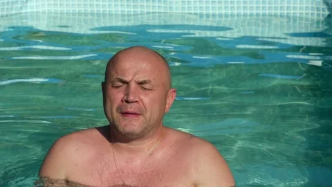Bald middle aged man in swimming pool on summer day Video stock 281507373