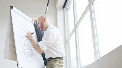 Bald Middle-Aged Mathematician Bending Over a Board Stock Footage 73121083