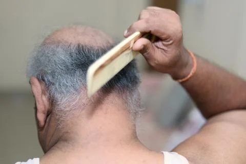 Bald Old man combing his hair with wooden comb in the morning Stock Photos