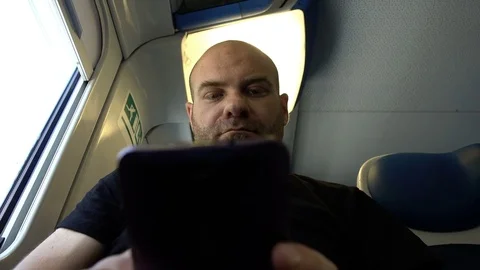 Bald passenger sitting on the train using the tablet Stock-Footage 78081335