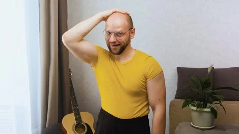 Bald seducer nerd moves his eyebrows, preens, flirts and points with two fingers Stock Footage 243756714