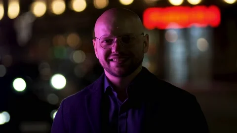 A bald, solid guy in a blue jacket looks at the camera and smiles Video stock 195911945