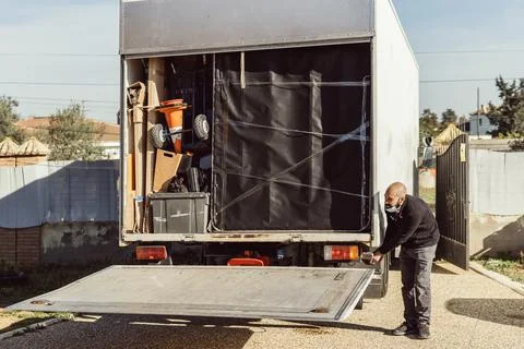 Bald worker closing the back of a moving truck Stock Photos