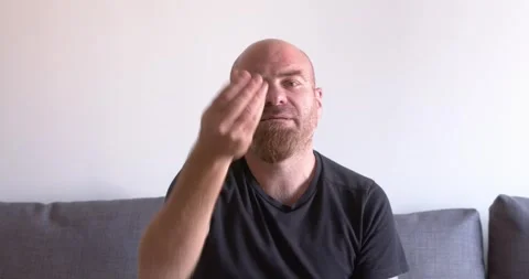 Bald young man on the couch making the classic Italian "What do you want?" gestu Stock Footage 303503316