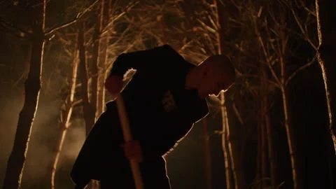 Bald young Man Digging a Grave with a Shovel in the forest Stock Footage 259116477
