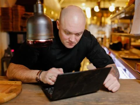 Bald young man looking at laptop Stock Photos