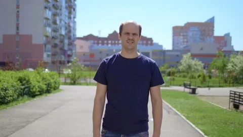 A balding man with a mustache fun dancing on city street. dance of the winner Stock Footage 130298997