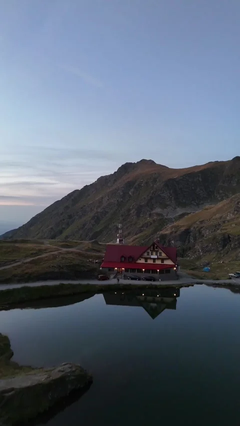 Balea Lake Chalet reflection at dusk in Carpathian Mountains Romania Stock Footage 335029996