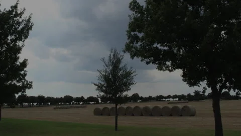 Baled hay in a field as clouds come up, 4K. Stock Footage 255049018