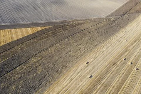 Bales of straw and abstract patterns in cornfield after wheat harvest behind Stock Photos
