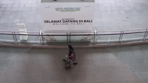 Bali, 10 Oct 2022: Two travelers walk past a large "Welcome to Bali" sign a.. Stock Footage 311286948
