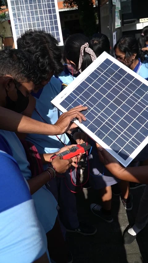Bali, 18 Jun 2023: Students outdoors test solar panels with multimeter, gai.. Stock Footage 311096135