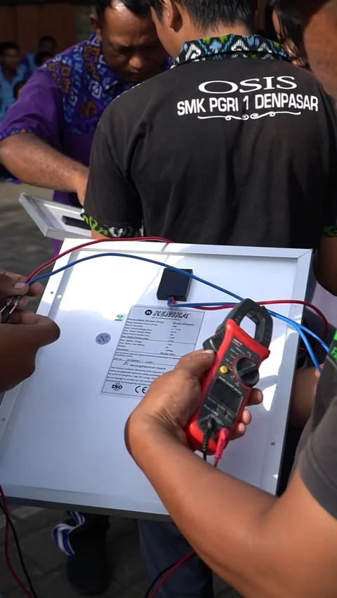 Bali, 18 Jun 2023: Students outdoors test solar panels with multimeter, gai.. Stock Footage 311096245