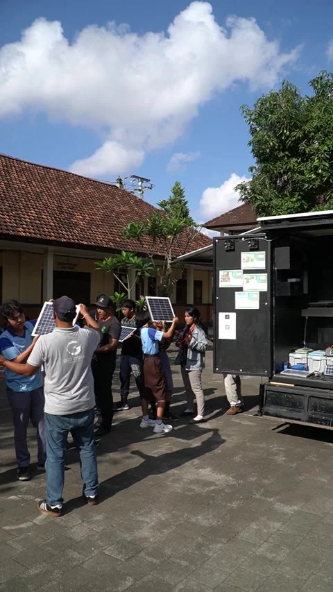 Bali, 18 Jun 2023: Students outdoors test solar panels with multimeter, gai.. Stock Footage 311096266