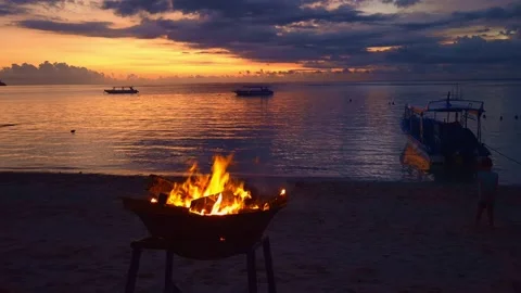 Bali Beach Firepit at Sunset with Anchored Boats Tropical Coastline Golden Hour Stock Footage 337739825